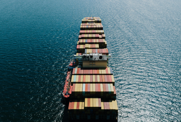 Aerial view of a cargo ship transporting shipping containers across the ocean